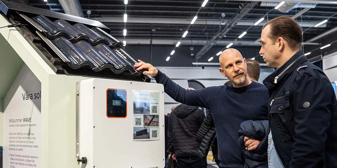 Två personer diskuterar solpanelteknik vid en utställningsmonter, symboliserande framtida hållbarhetslösningar